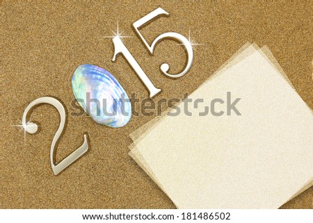 Year 2015 numbers with blank paper card on the sand