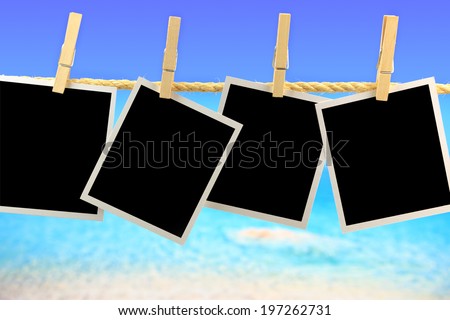 Photo frames hanging on a rope in front of the sea