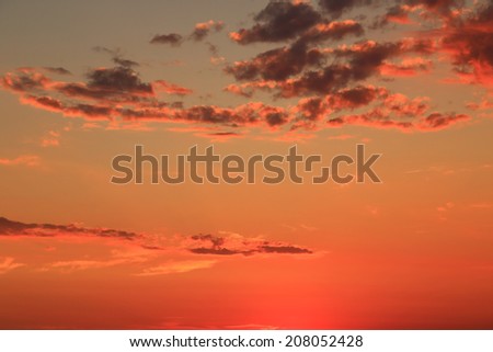Vivid peach sunset sky with light clouds