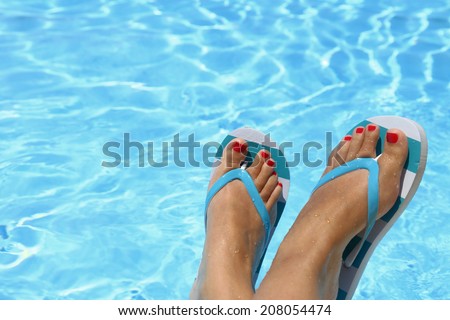 Female wet feet with flip flops by the pool