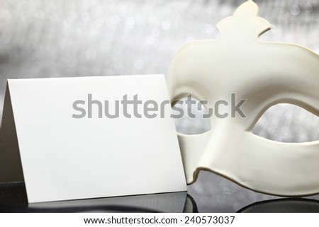 White mask in front of glittering background