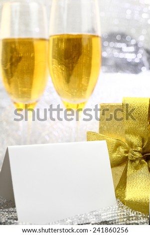 Card with two glasses of champagne and gold gift box