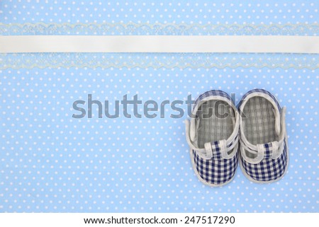 Baby shoes on blue polka dots background