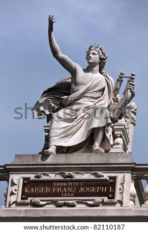 Statue of Orpheus holding a lyre in an ancient Greek style on top of a building in Vienna.