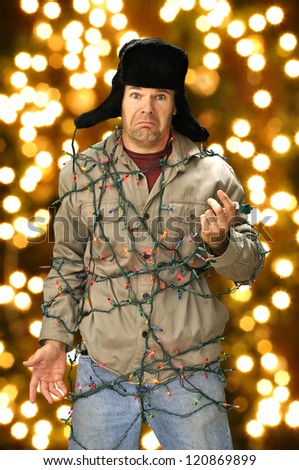 Funny confused man wrapped in colorful Christmas lights