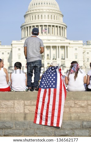 WASHINGTON D.C. - APRIL 10: Demonstrators show their American patriotism in front of the capitol during a demonstration for immigration reform in Washington D.C. on April 10, 2013.
