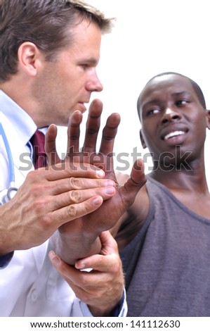 White medical doctor tests pain tolerance of young athletic black man\'s wrist on white background