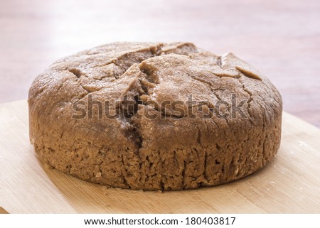 Moist homemade loaf of sourdough bread on cutting board in natural lighting