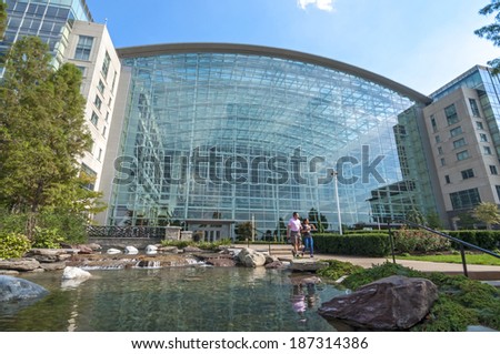 NATIONAL HARBOR, USA - OCTOBER 5, 2014: A vacationing couple walk down the steps from the beautifully designed atrium of the Gaylord National Resort and Convention Center in National Harbor, Maryland