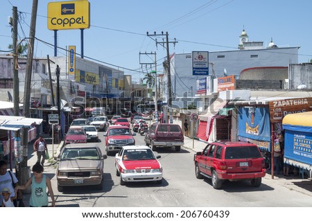 LAS CHOAPAS, MEXICO - JULY 17, 2014: Vehicle and pedestrian traffic flows on even a hot sunny day in downtown Las Choapas, Veracruz.