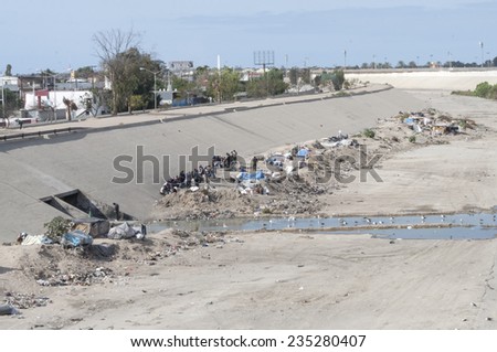 TIJUANA, MEXICO - NOVEMBER 13, 2014: Growing homeless camps of pitched tents and garbage are a sad sight seen from the pedestrian bridge that crosses the Tijuana River flood channel
