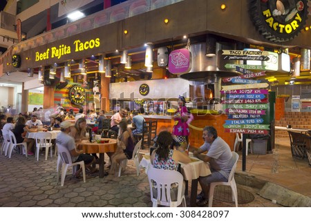 CANCUN, MEXICO - JULY 27, 2015: Tourists enjoy eating at the Taco Factory, a popular restaurant offering tasty Mexican food in Cancun\'s hotel zone