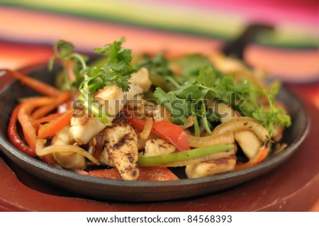Hot skillet of chicken fajitas and vegetables