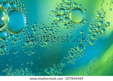 Abstract blue and green bubbles of water floating like a swarm on a blurry colored background