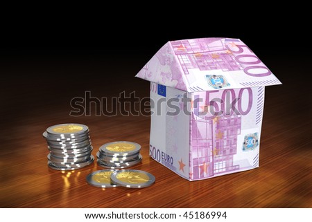 Financing of properties. A house build from 500 Euro banknotes, next to stacks of 2 Euro coins on a polished wooden table.
