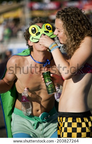 Budapest, Hungary - August 13th 2010: A young adult couple drinking beer and alcohool shots at sunset in the main stage area of the Sziget Festival