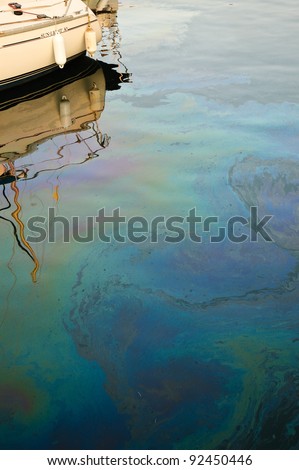 Rainbow oil pollution in the water leaked from the nearby boat.