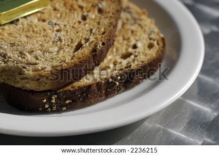 Detail of whole wheat seeded sliced bread toasted on a white plate on a cafe table