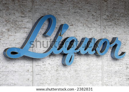 A weathered and cracked sixties Liquor store sign on a wall