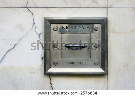 A steel night deposit box in the marble wall of a bank