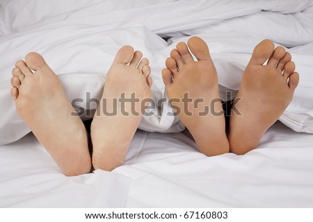 Happy Feet. Pair of Feet under the blanket , Close up
