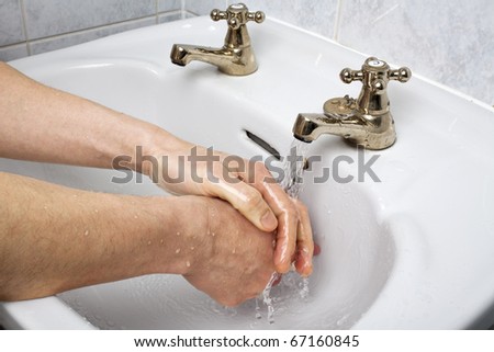 Hand washing in basin. Man washing hand under running water