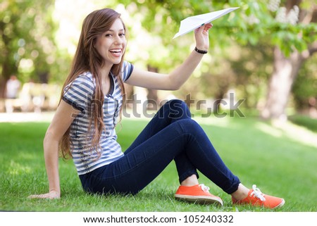 Young woman throwing paper plane