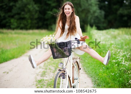 Woman riding bicycle with her legs in the air Woman riding bicycle with her legs in the air