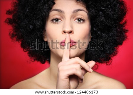 Woman with afro making silence gesture