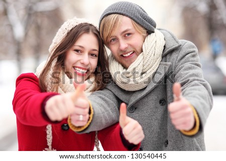 Winter couple with thumbs up