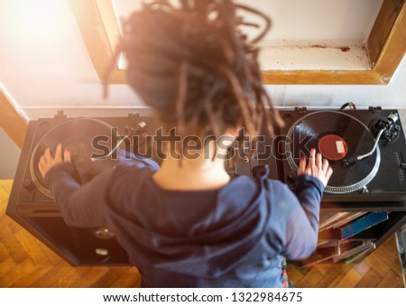 Woman disc jockey working with vinyl records, overhead view