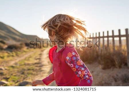 Little girl running through the Spanish landscape, Rambla del Playazo, Cabo de Gata - Nijar Natural Park, Spain