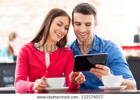 Couple using digital tablet in cafe Couple using digital tablet in cafe