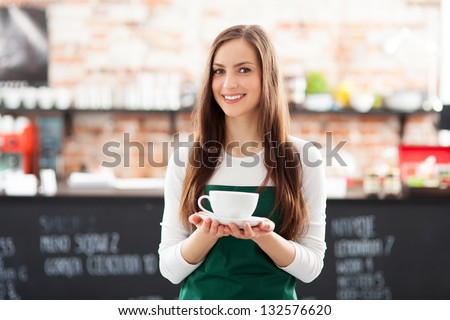 Waitress Holding Cup Of Coffee In Cafe