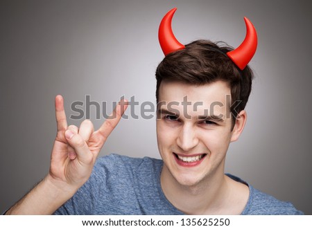 Man wearing devil horns