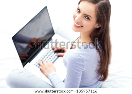 Woman sitting on bed with laptop Woman sitting on bed with laptop