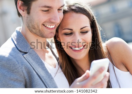 Smiling Couple With Mobile Phone