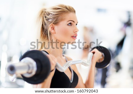 Woman in gym lifting weights Woman in gym lifting weights