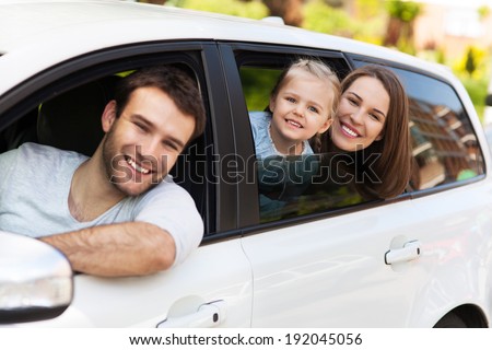 Family sitting in the car looking out windows
