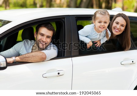 Family sitting in the car looking out windows