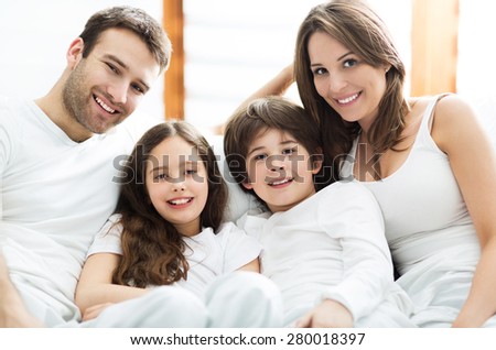Smiling family in bed