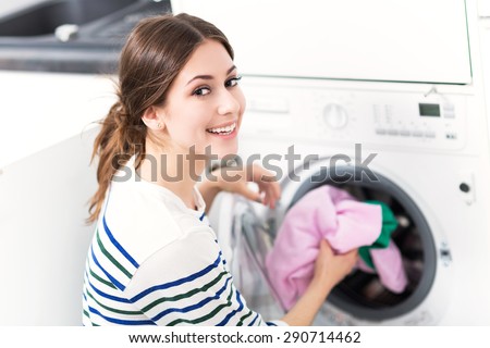 Woman loading washing machine
