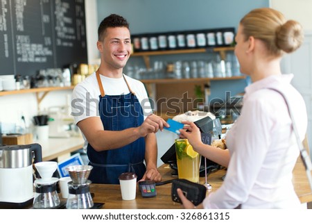 Barista serving customer in coffee shop