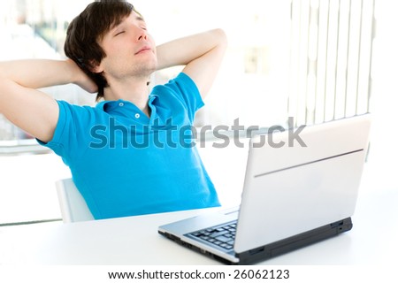 Man with laptop, hands behind head