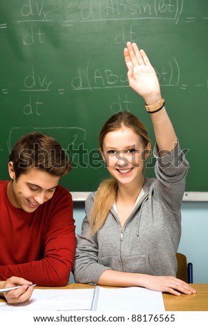 Clever student in classroom raising hand