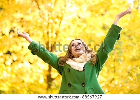 Autumn woman standing with arms raised