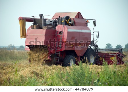 Red grain harvester combine in a field. Combine made in the Republic of Belarus.