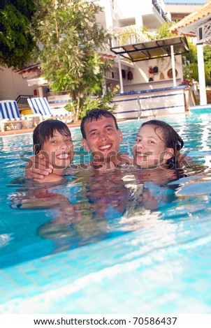 Happy family in the swimming pool of luxury hotel
