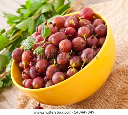red gooseberries in a yellow bowl