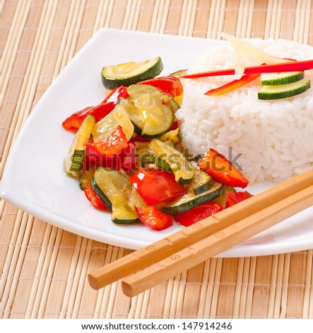 Plate of vegetable fried rice and chopstick.